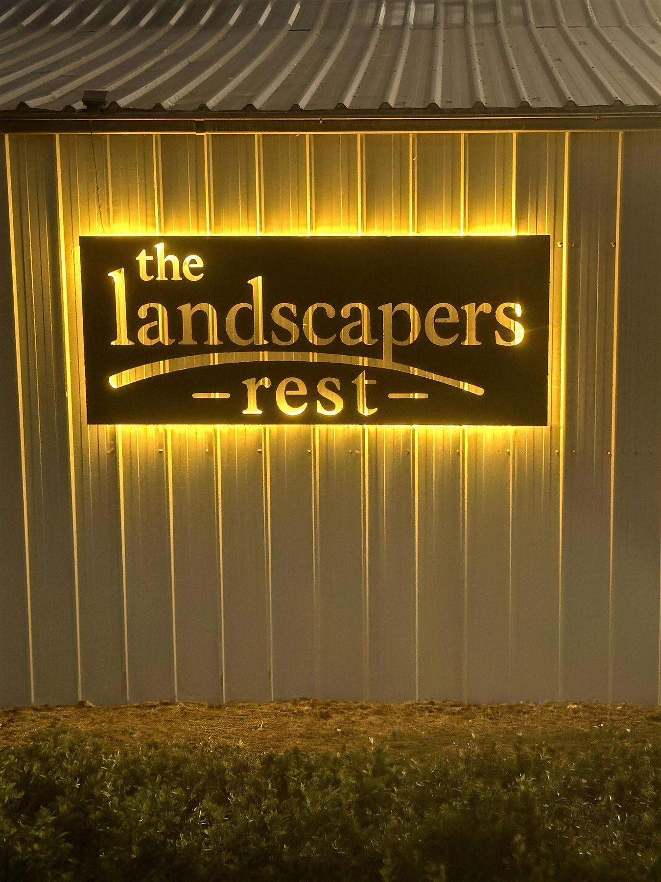 The Landscapers Rest illuminated sign at night